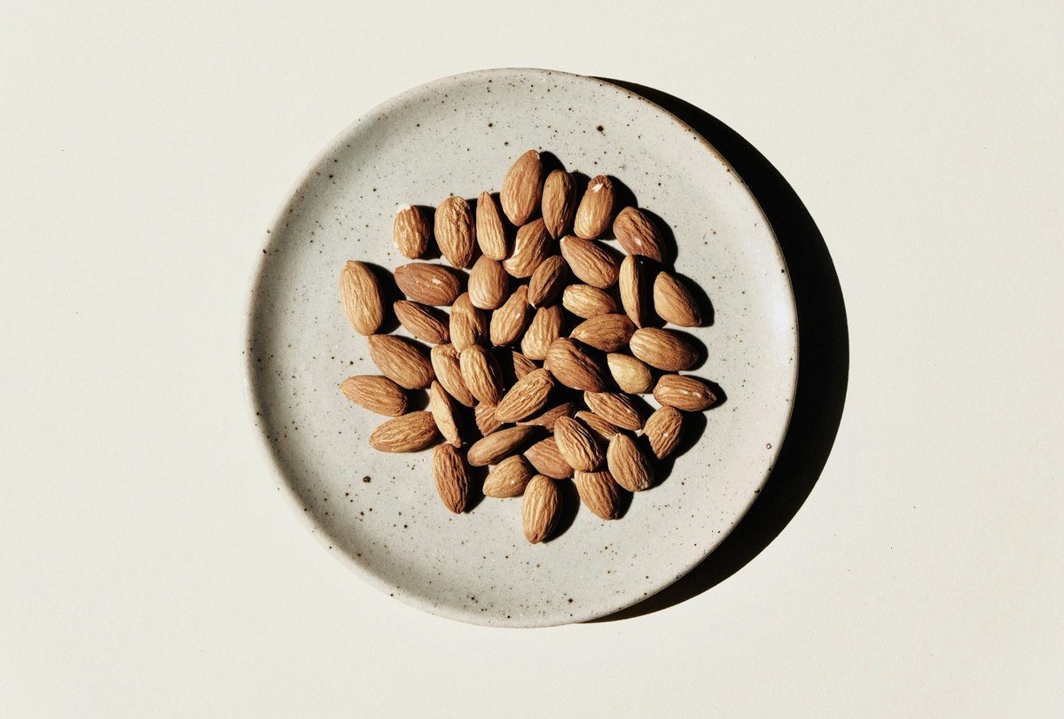 Amandes dans une assiette en grès posée sur une table
