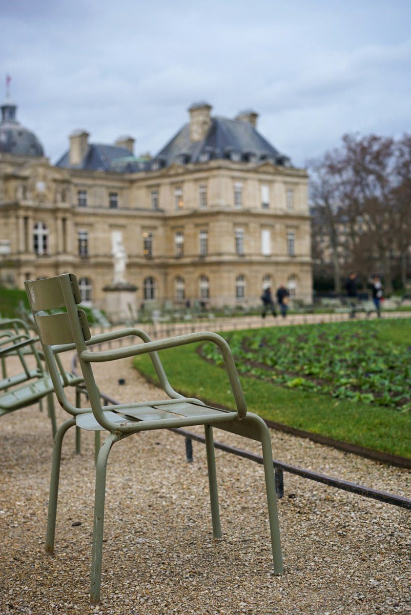Chaises de jardin vert pâle posées sur le gravier d'un parc