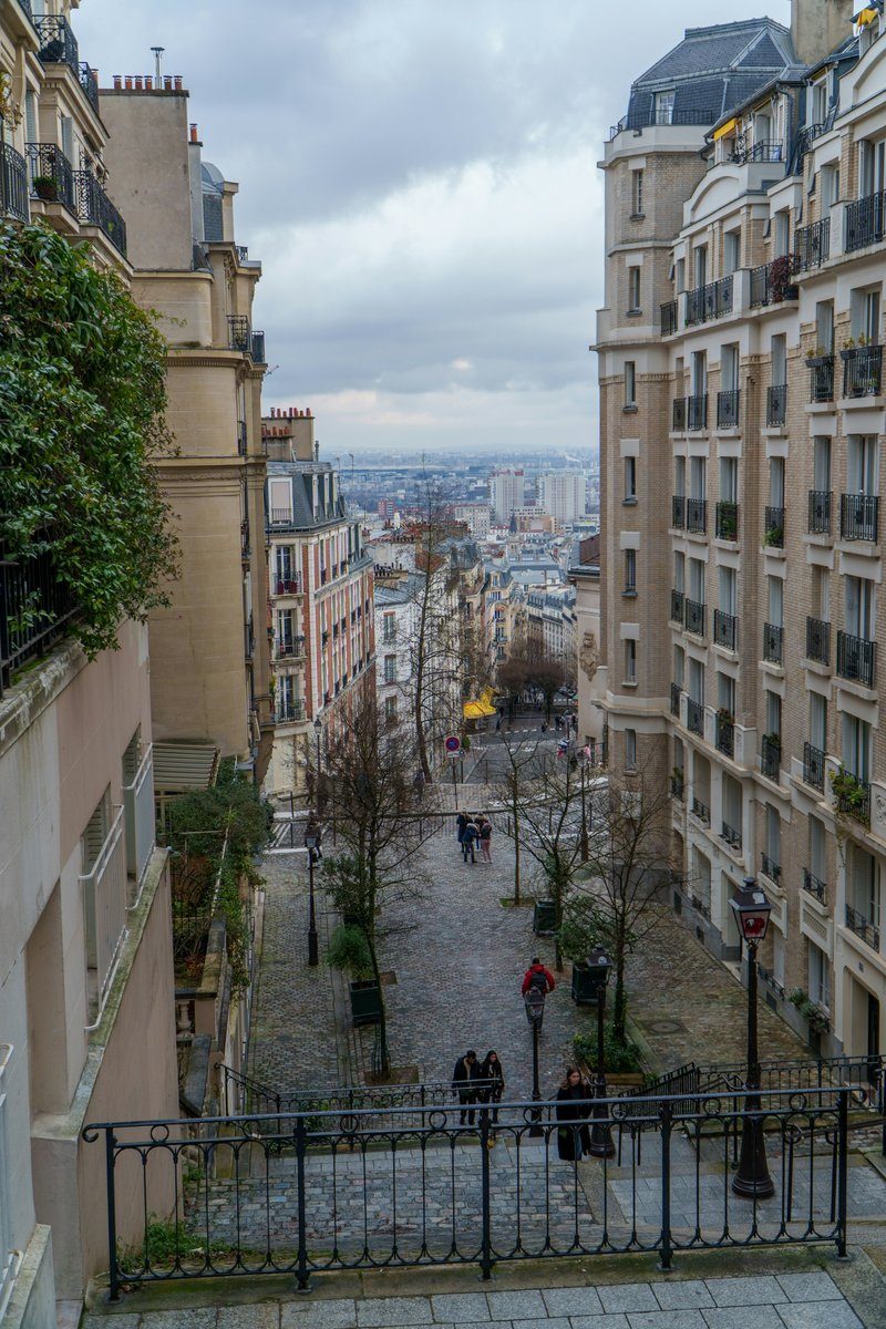 Escalier qui descend vers la ville entre deux immeubles