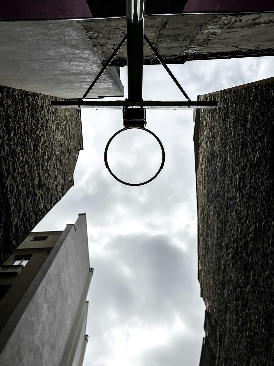 Panier de basket vu d'en dessous, entre deux murs d'immeubles