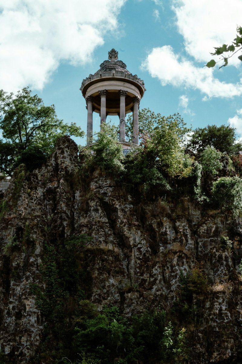 Petit temple au sommet d'un rocher, au milieu d'un parc parisien arboré