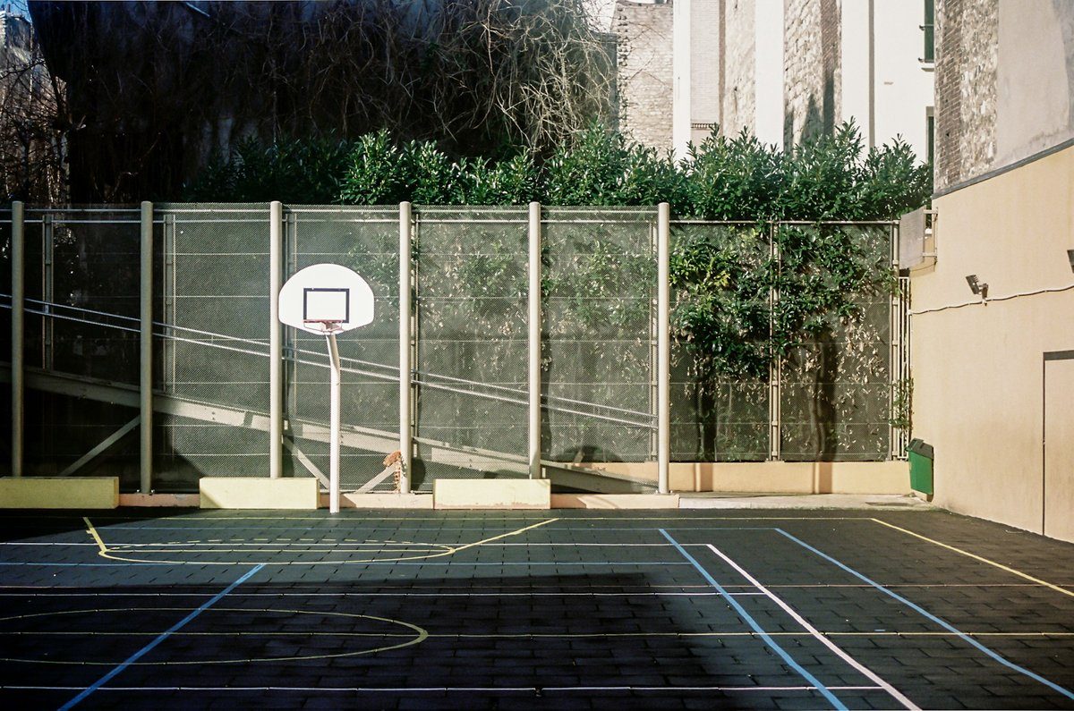Terrain de basket de quartier vu à travers un grillage